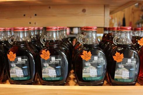 This image shows bottles of maple syrup made by Green Chimneys students are one of our store's most popular items.
